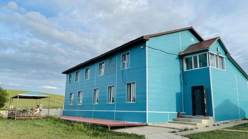 a blue building in the middle of a field at Gaya's Guest House in Harhorin