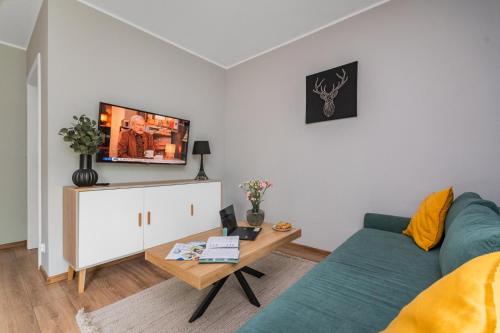 a living room with a blue couch and a table at Przystanek Jantar - pokoje i apartamenty in Jantar