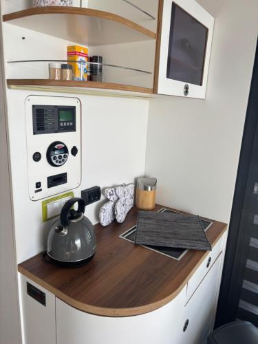 a tiny kitchen with a counter in a tiny house at WOHLFÜHLBOOT Hausboot - Festlieger in der Marina Zaue am Schwielochsee - incl Stand Up Board in Schwielochsee