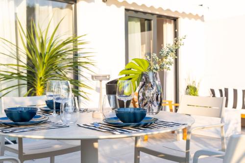 a white table with plates and glasses on a patio at Urban Rooftop Apartment in Dubrovnik