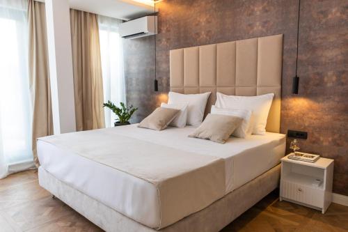 a bedroom with a large white bed with a large headboard at Urban Rooftop Apartment in Dubrovnik