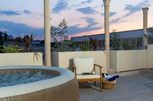 a bath tub sitting on a patio with a chair at Urban Rooftop Apartment in Dubrovnik