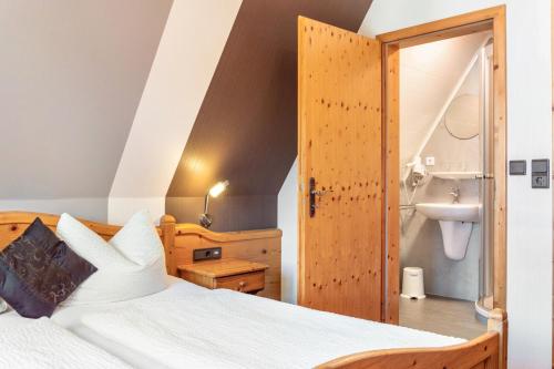 a bedroom with a bed and a bathroom at Wein- und Gästehaus Lutz in Iphofen
