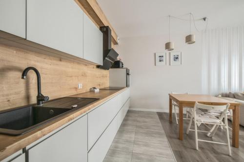 a kitchen with a sink and a table at Baltiq Plaza by NorthSide Apartments in Gdynia