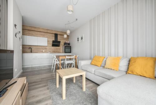 a living room with a couch and a table at Baltiq Plaza by NorthSide Apartments in Gdynia