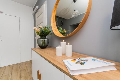 a bathroom with a mirror and candles on a counter at Przystanek Jantar - pokoje i apartamenty in Jantar