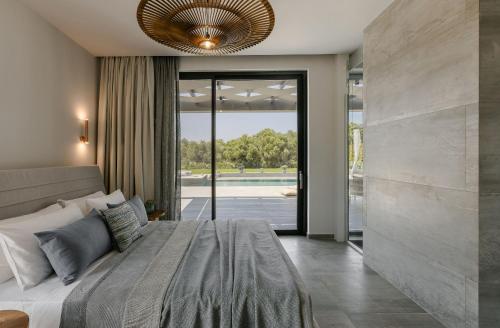 a bedroom with a large bed and a large window at Aegiali Luxury Villa in Kaligata