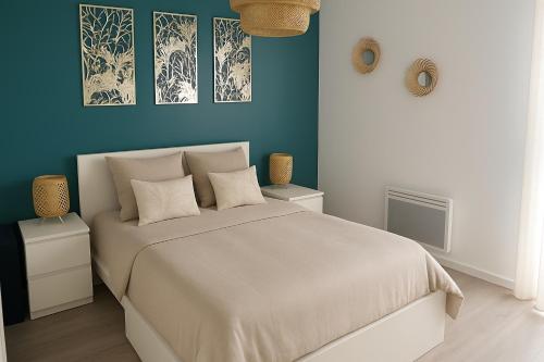 une chambre avec un grand lit aux murs bleus dans l'établissement L’horizon bleu, à Saint-Hilaire-de-Riez