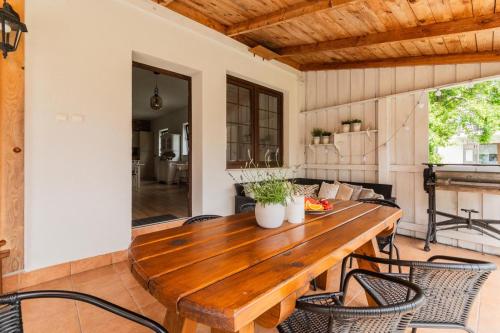 a wooden table and chairs on a patio at Przystanek Jantar - pokoje i apartamenty in Jantar