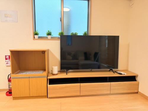 a large entertainment center with a large flat screen tv at 池袋銀婚屋 GINKOU's HOUSE -- 2 min train to Ikebukuro Sunshine City in Tokyo