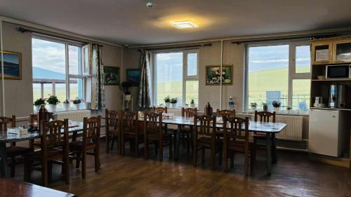 a dining room with tables and chairs and windows at Gaya's Guest House in Harhorin