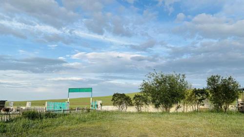 a blue sign in the middle of a field at Gaya's Guest House in Harhorin