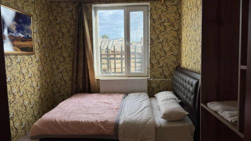 a small bedroom with a bed and a window at Gaya's Guest House in Harhorin