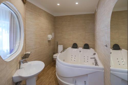 a bathroom with a tub and a sink and a toilet at Atpūtas komplekss Lilaste in Lilaste