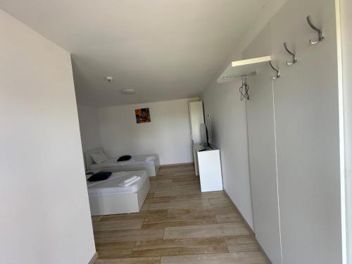 a white bathroom with a toilet and a sink at Pensiunea La Miluta in Caraorman