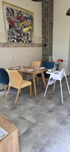 a dining room with tables and chairs and a painting at Charmantes Studio Ferienhaus mit Garten & Netflix Nähe Spreewald in Heinersbrück