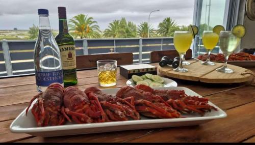 a plate of lobsters on a table with a bottle of wine at Velddrif Riverside Guesthouse in Velddrif