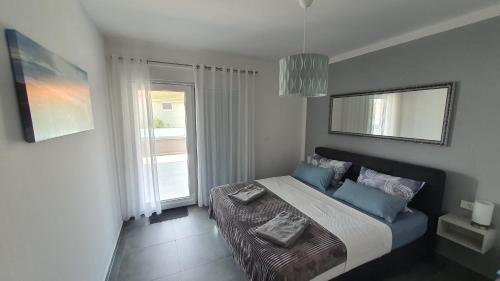 a bedroom with a bed with blue pillows and a window at Ferienwohnung Adriaperle Villa Casper mit Whirlpool in Palit