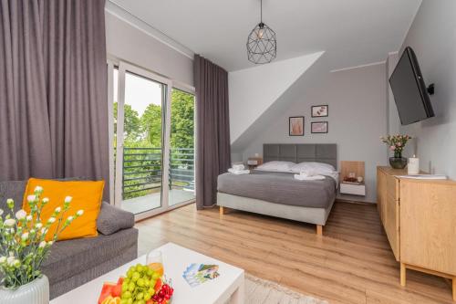 a bedroom with a bed and a living room at Przystanek Jantar - pokoje i apartamenty in Jantar