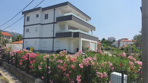 a white building with pink flowers in front of it at Ferienwohnung Adriaperle Villa Casper mit Whirlpool in Palit