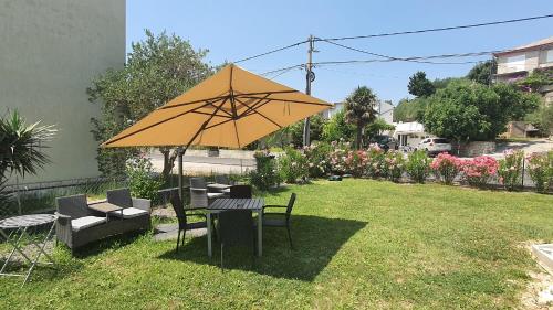 a table and chairs with an umbrella in a yard at Ferienwohnung Adriaperle Villa Casper mit Whirlpool in Palit