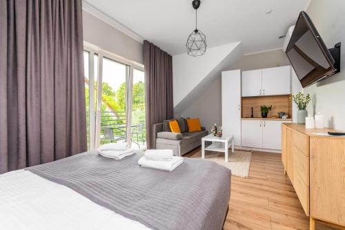 a bedroom with a bed and a living room at Przystanek Jantar - pokoje i apartamenty in Jantar