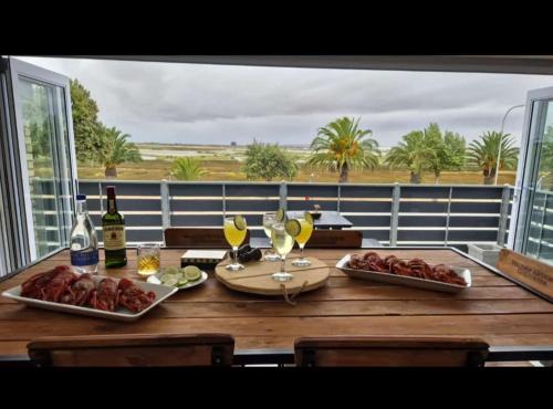 a table with food and wine on a balcony at Velddrif Riverside Guesthouse in Velddrif