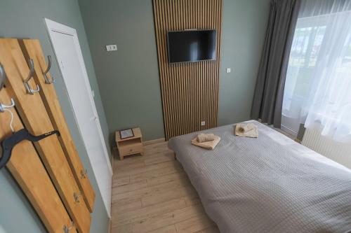 a bedroom with a bed with two towels on it at Atpūtas komplekss Lilaste in Lilaste