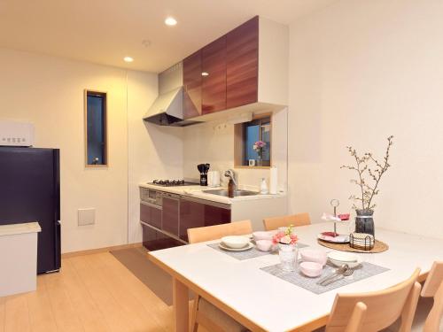 a kitchen with a white table and chairs in a room at 池袋銀婚屋 GINKOU's HOUSE -- 2 min train to Ikebukuro Sunshine City in Tokyo