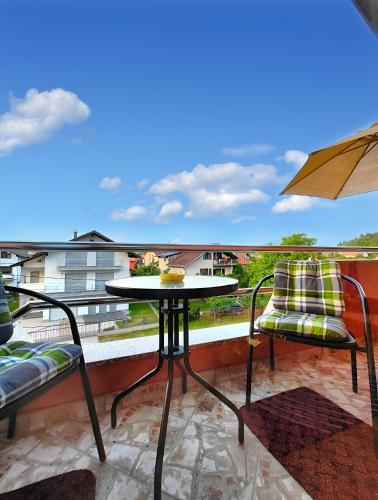a balcony with a table and two chairs and an umbrella at Apartman Una Paradies in Bihać