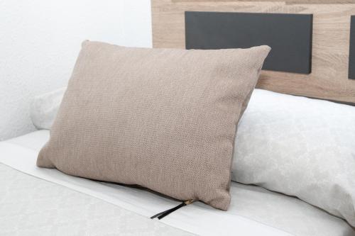 a pillow sitting on top of a bed at Apartamento De Diseño Con Piscina Junto Al Mar GANDIAZAR IV in Playa de Gandia