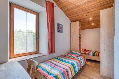 une petite chambre avec un lit et une fenêtre dans l'établissement Maison Orange, à Aspiran