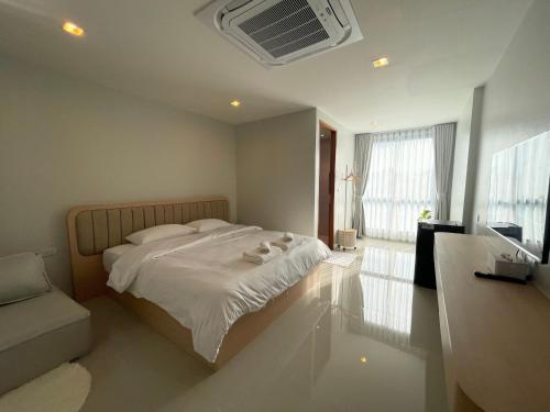 a bedroom with a white bed and a window at HOMETELhdy in Hat Yai