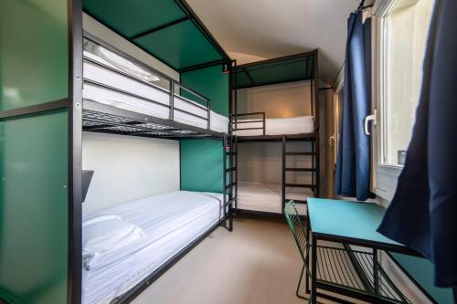 a room with bunk beds and a table and a chair at YellowSquare Milan in Milan