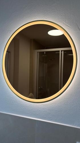 a circular mirror on a wall in a bathroom at Bio-Nestlein Apartments in Löffingen