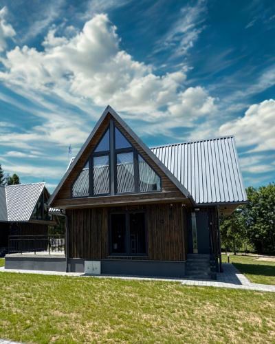 a house with a gambrel roof with a large window at Grzeszne Chatki - Smerek in Smerek