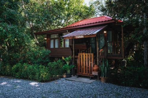 a small wooden cabin with a porch and a gate at บ้านสวนแก้วคำแพง Baan Suan Kaew Khampaeng in Udon Thani