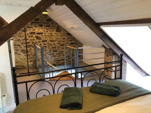 a room with a bed with a staircase in the background at Petit Noyer in Val Couesnon
