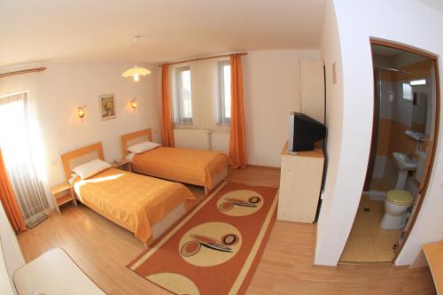 a hotel room with two beds and a television at Pensiunea Maria , Floresti in Floreşti