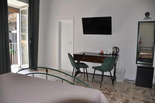 a bedroom with a desk and chairs and a bed at Asmundo Palace Suites & Spa in Catania