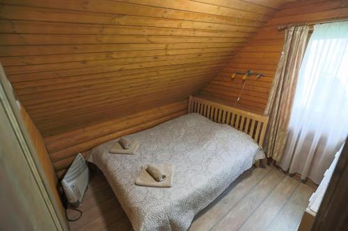 a small bedroom with a bed in a wooden room at Atpūtas komplekss Lilaste in Lilaste