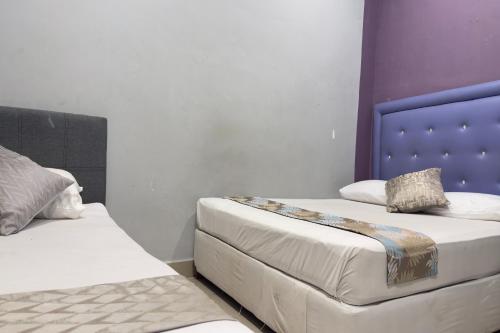 two beds sitting next to each other in a room at Hotel 3Winz, Chow Kit Hospital Kuala Lumpur in Kuala Lumpur