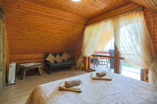 a bedroom with a bed and a couch in a room at Atpūtas komplekss Lilaste in Lilaste
