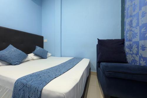 a bed and a chair in a room at Hotel 3Winz, Chow Kit Hospital Kuala Lumpur in Kuala Lumpur