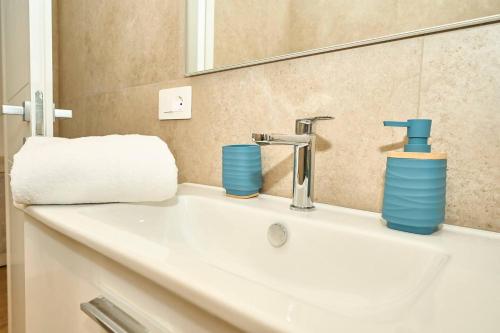 a bathroom sink with blue cups and a mirror at Allegra elegance homes in Nettuno