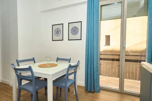 a dining room with a white table and blue chairs at Allegra elegance homes in Nettuno
