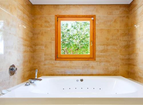 a bath tub in a bathroom with a window at Villa Can Cardona Sea views Perfect 4 families in Sant Rafael de Sa Creu