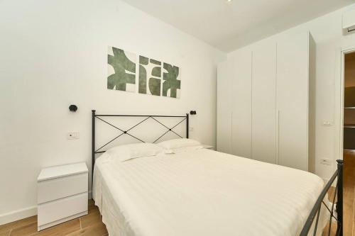 a bedroom with a white bed and a white cabinet at Allegra elegance homes in Nettuno