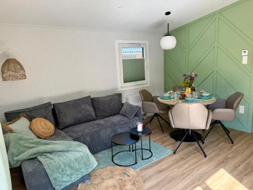 a living room with a couch and a table at Natursee-Chalet, Angeln, Wellness, Spa, Ponyhof in Twist