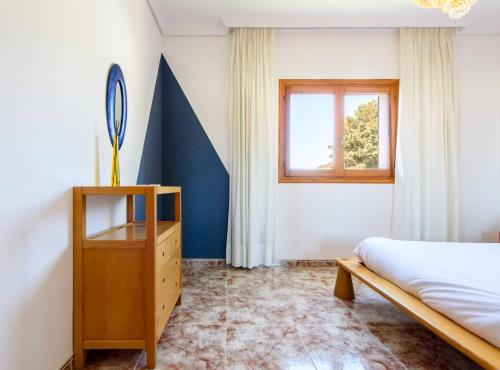 a bedroom with a bed and a dresser and a window at Villa Can Cardona Sea views Perfect 4 families in Sant Rafael de Sa Creu